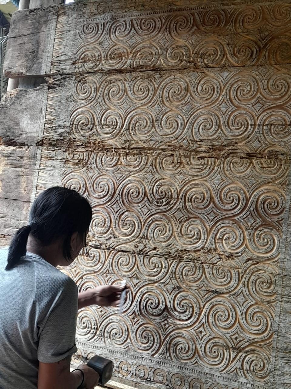 Hands carefully carving wood